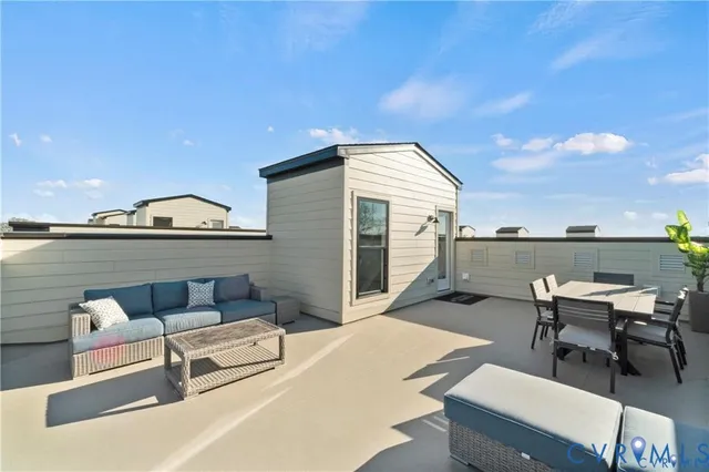 a roof deck with table and chairs