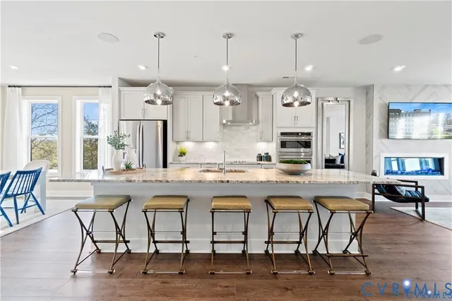 a kitchen with stainless steel appliances granite countertop a table and chairs in it