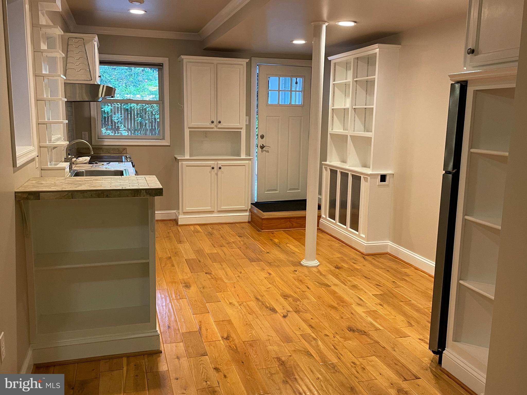2442 20th Street Northwest, Unit B Washington, DC 20009 - Photo 14 of 19 a room with kitchen island a sink cabinets and refrigerator
