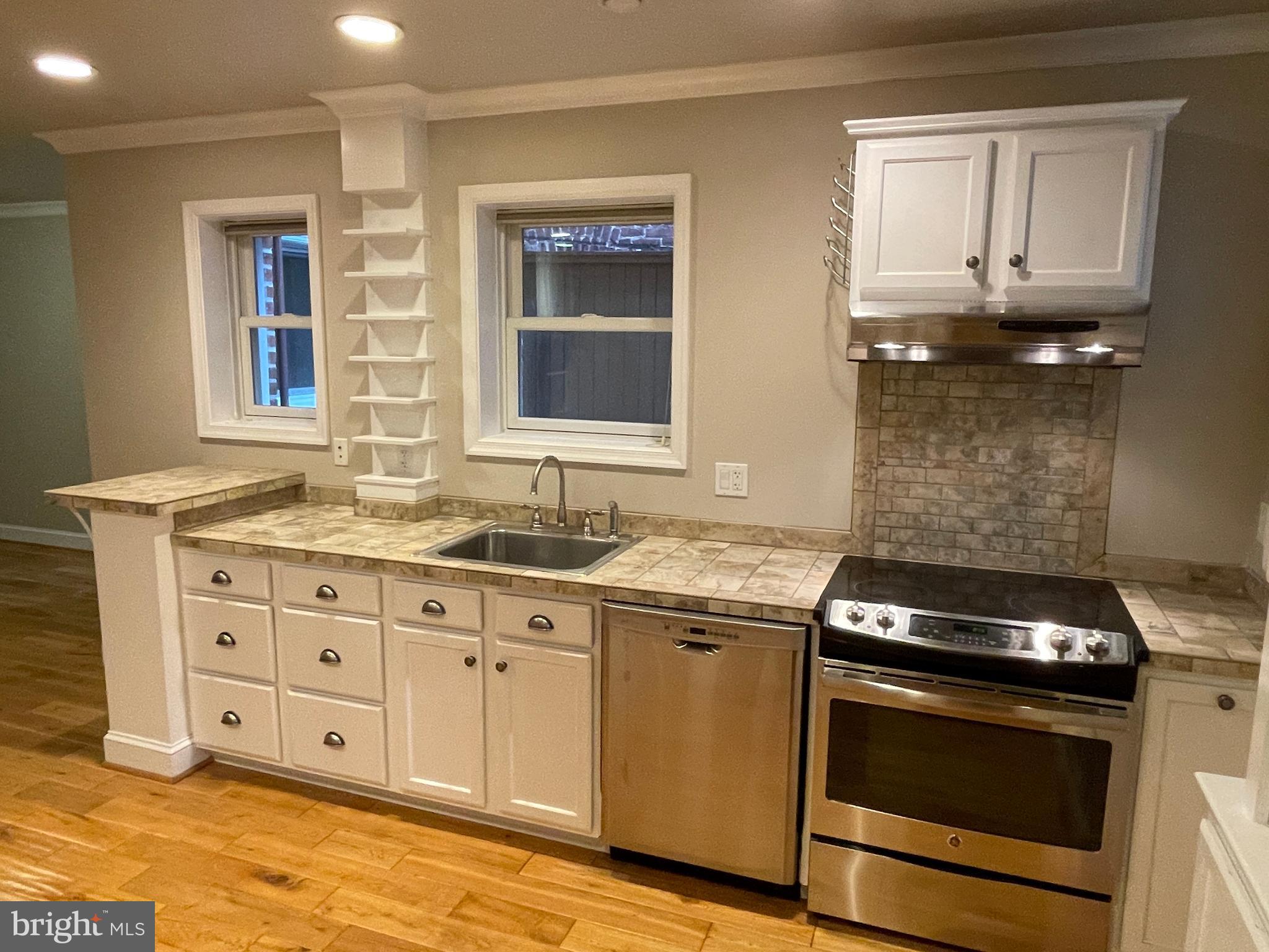 2442 20th Street Northwest, Unit B Washington, DC 20009 - Photo 15 of 19 a kitchen with stainless steel appliances granite countertop a stove and a sink