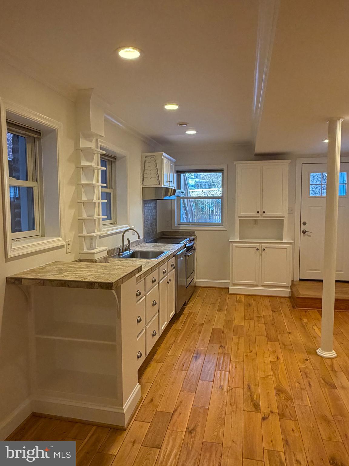 2442 20th Street Northwest, Unit B Washington, DC 20009 - Photo 10 of 15 a large kitchen with kitchen island a sink stainless steel appliances and cabinets