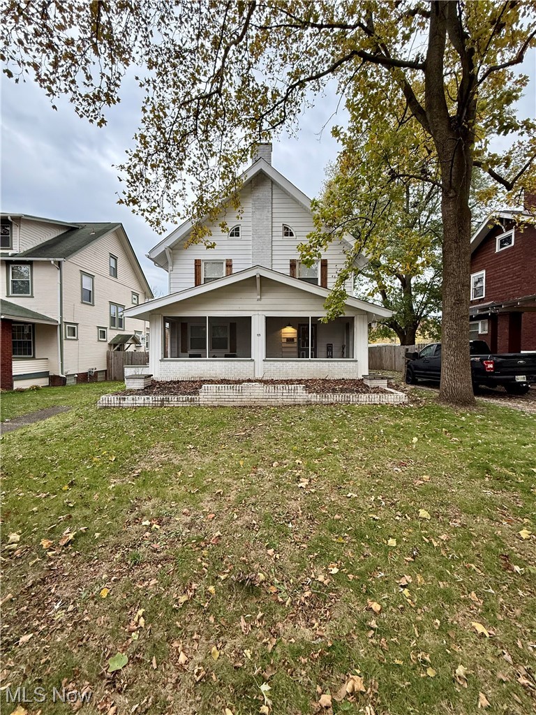Rear view of property featuring a chimney and a sunroom