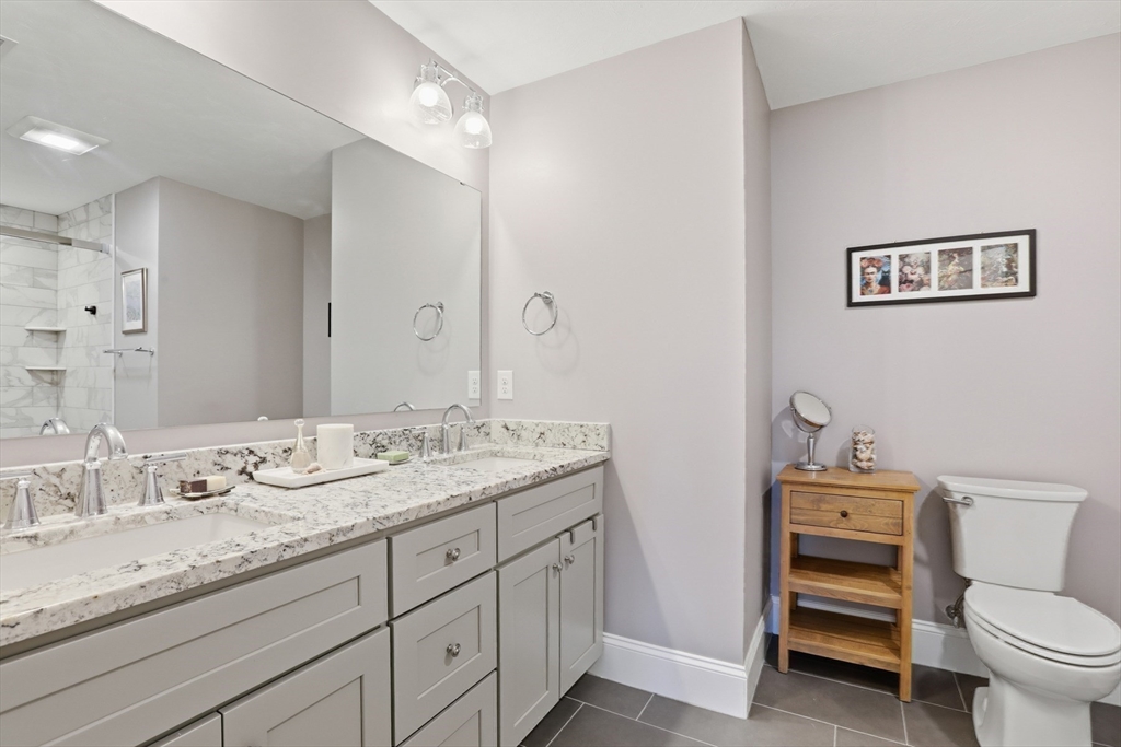 47 Cutter Lane, Unit 47 Amesbury, MA 01913 - Photo 15 of 33 a bathroom with a granite countertop toilet sink and mirror