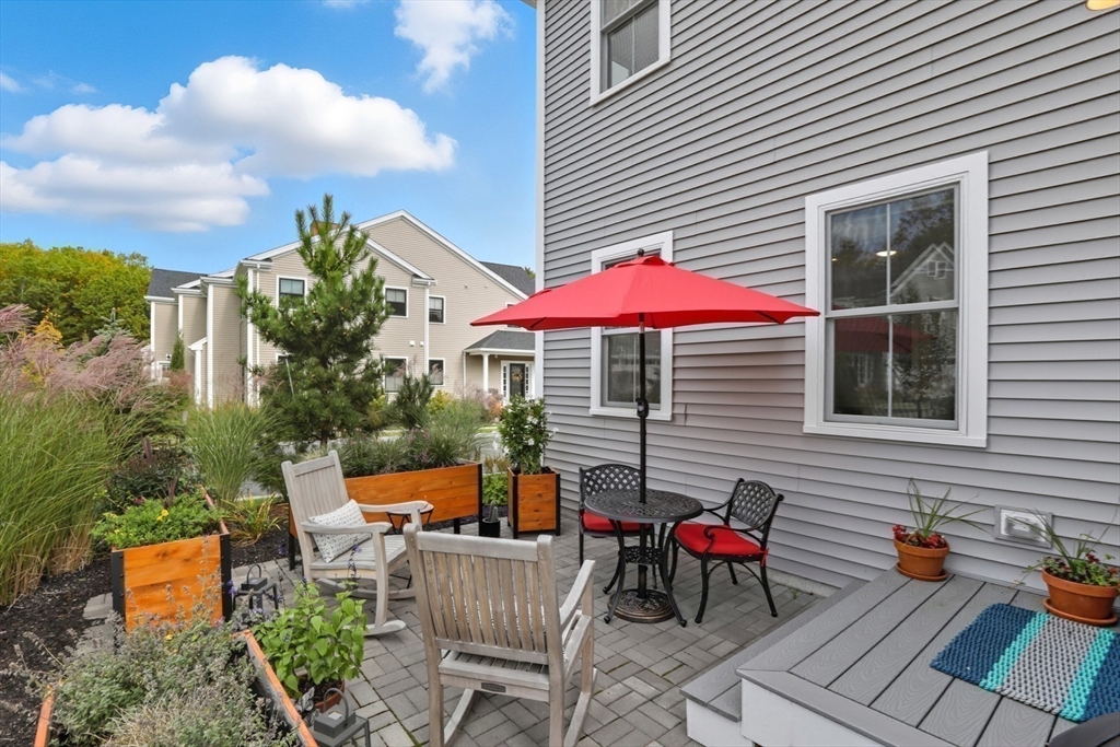 47 Cutter Lane, Unit 47 Amesbury, MA 01913 - Photo 27 of 33 an outdoor space with furniture and umbrella