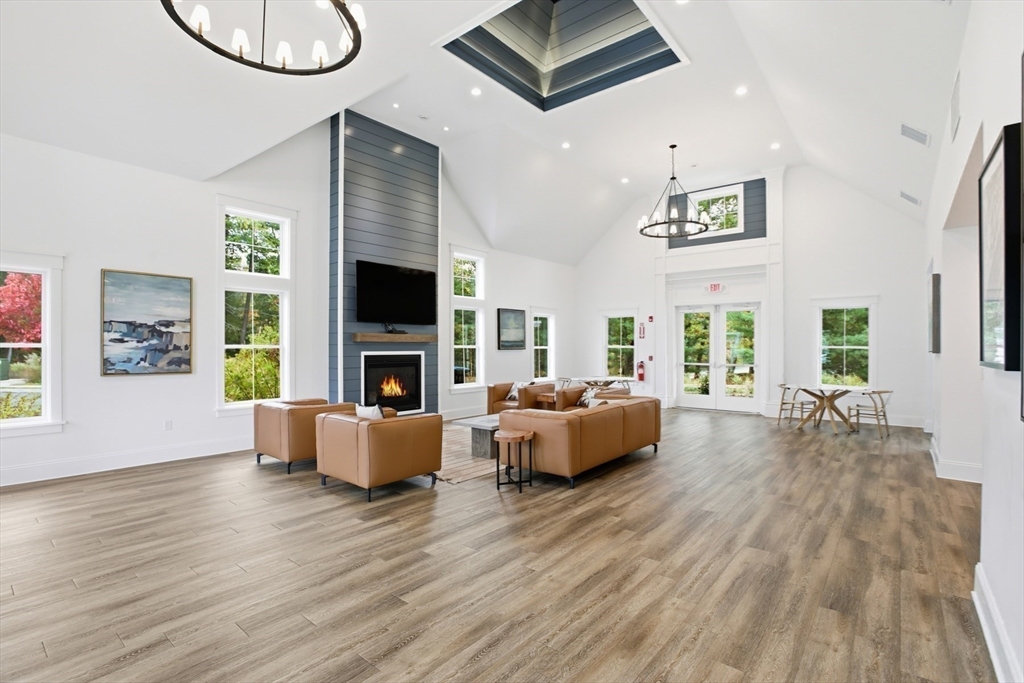 47 Cutter Lane, Unit 47 Amesbury, MA 01913 - Photo 30 of 33 a living room with fireplace furniture and a wooden floor