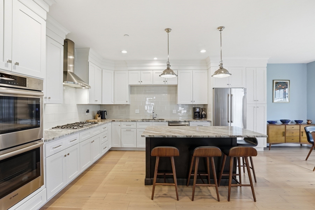 47 Cutter Lane, Unit 47 Amesbury, MA 01913 - Photo 4 of 33 a kitchen with stainless steel appliances granite countertop a table chairs stove and white cabinets