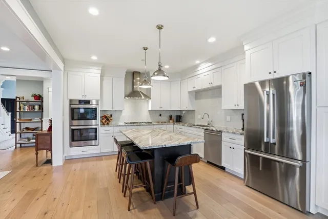 a kitchen with kitchen island a large counter top space appliances and cabinets