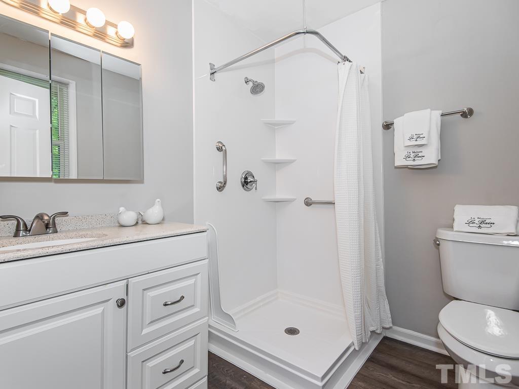 7014 Kemp Road Raleigh, NC 27613 - Photo 18 of 43 a bathroom with a granite countertop toilet sink and shower