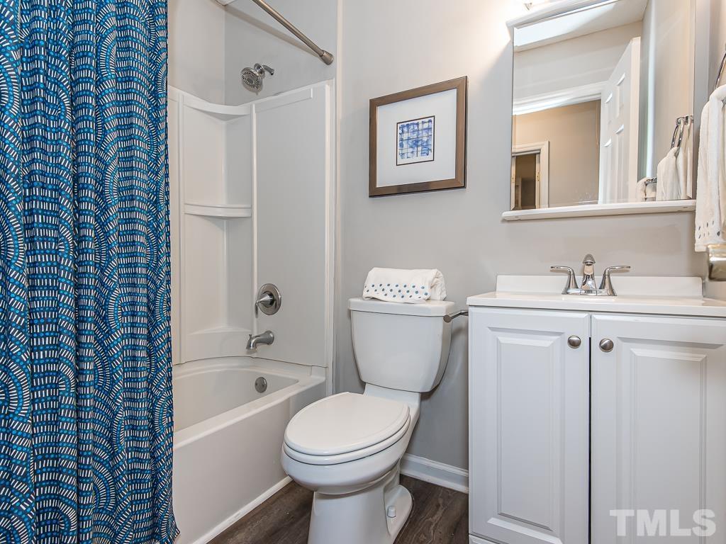 7014 Kemp Road Raleigh, NC 27613 - Photo 21 of 43 a white toilet sitting next to a bathroom sink and tub