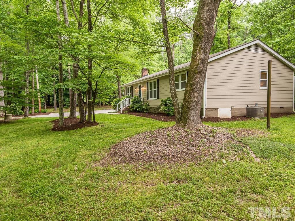 7014 Kemp Road Raleigh, NC 27613 - Photo 33 of 43 a front view of house with a garden and trees
