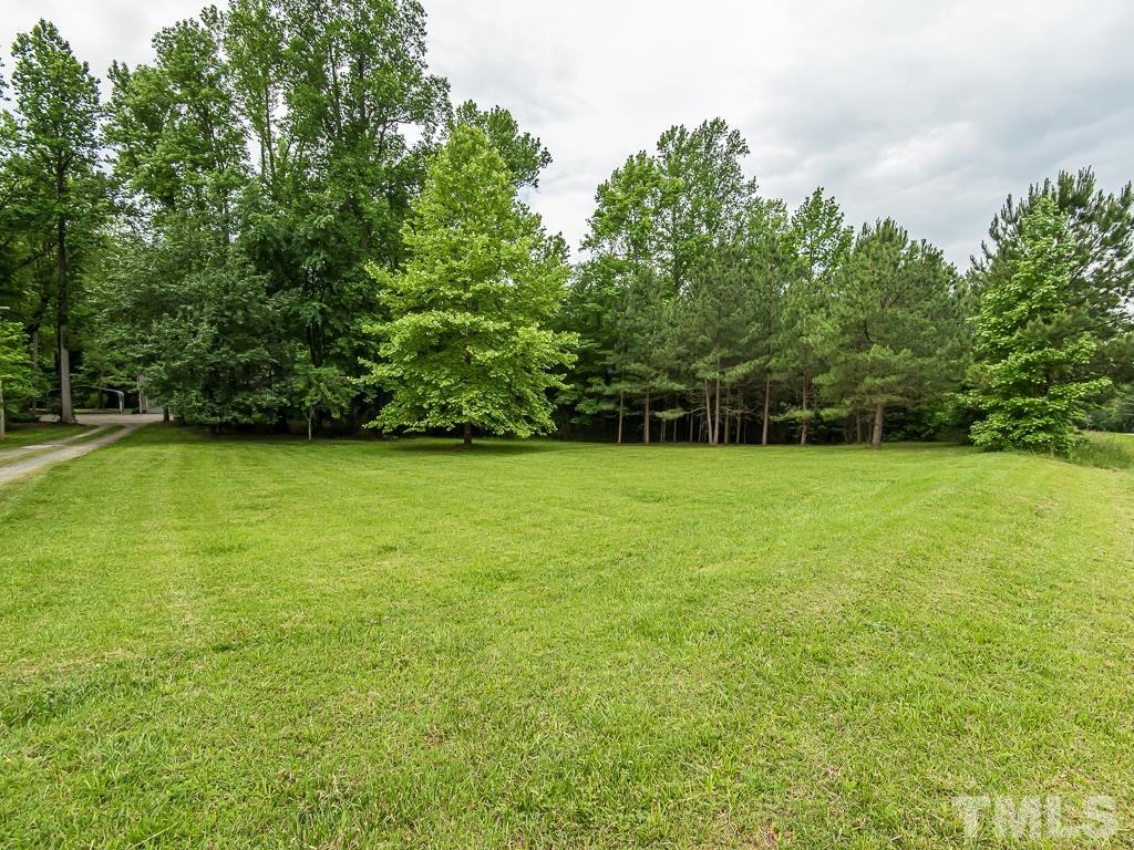 7014 Kemp Road Raleigh, NC 27613 - Photo 43 of 43 a view of a green field with wooden fence