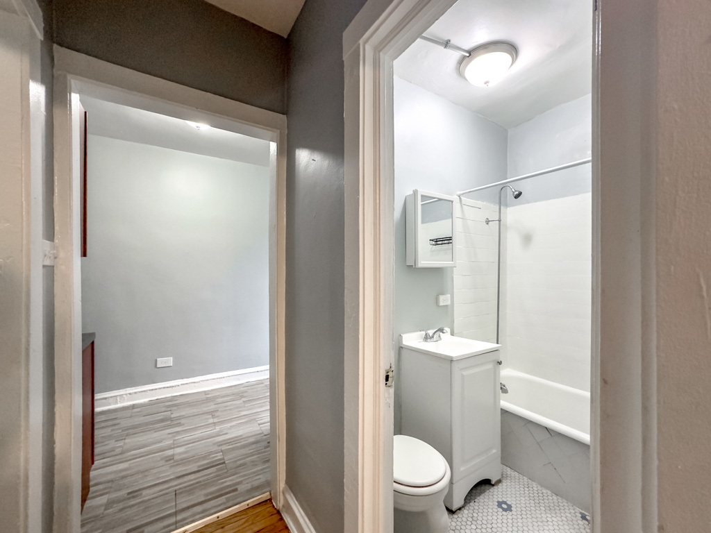 4606 North Beacon Street, Unit 2C Chicago, IL 60640 - Photo 15 of 21 a bathroom with a toilet a sink and shower