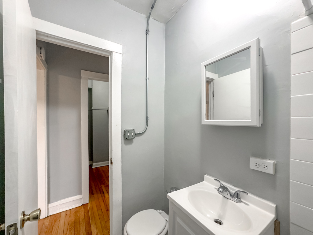 4606 North Beacon Street, Unit 2C Chicago, IL 60640 - Photo 17 of 21 a bathroom with a toilet sink and mirror