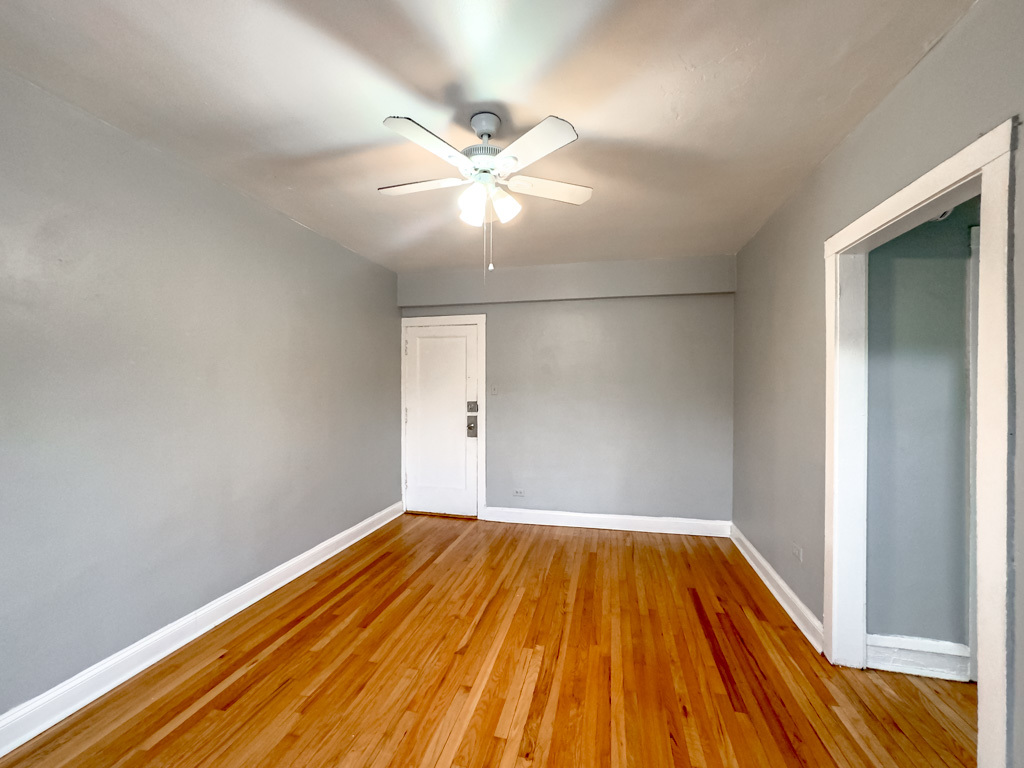4606 North Beacon Street, Unit 2C Chicago, IL 60640 - Photo 19 of 21 a view of a room with wooden floor and a ceiling fan