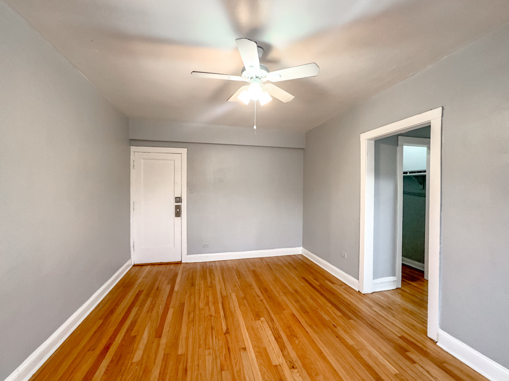 4606 North Beacon Street, Unit 2C Chicago, IL 60640 - Photo 20 of 21 a view of a room with wooden floor a ceiling fan and window