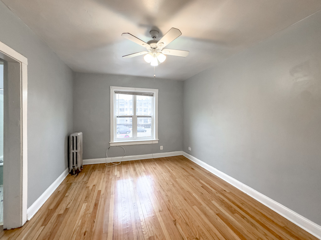 4606 North Beacon Street, Unit 2C Chicago, IL 60640 - Photo 21 of 21 an empty room with wooden floor fan and windows