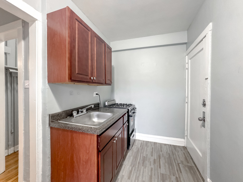 4606 North Beacon Street, Unit 2C Chicago, IL 60640 - Photo 3 of 21 a kitchen with granite countertop a sink stove and cabinets