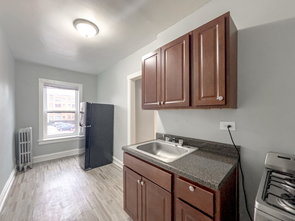 4606 North Beacon Street, Unit 2C Chicago, IL 60640 - Photo 5 of 21 a kitchen with stainless steel appliances granite countertop a refrigerator a sink dishwasher and wooden cabinets with wooden floor