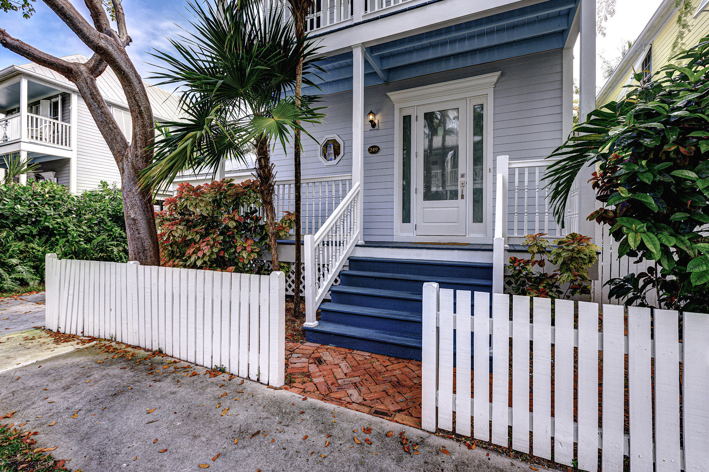 249 Golf Club Drive Key West, FL 33040 - Photo 2 of 11 a view of a house with a small yard and wooden fence and trees