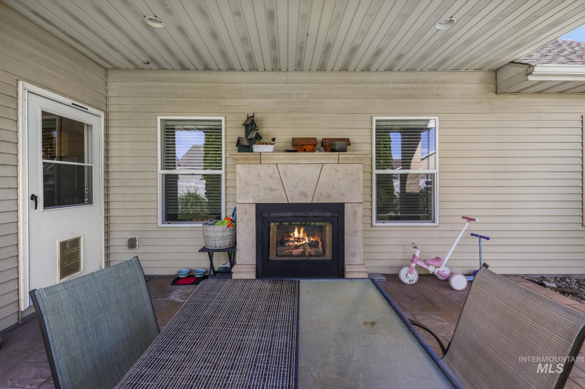 467 Wildrose Loop Twin Falls, ID 83301 - Photo 34 of 46 Covered patio with a stone-clad outdoor fireplace featuring a hearth and mantle