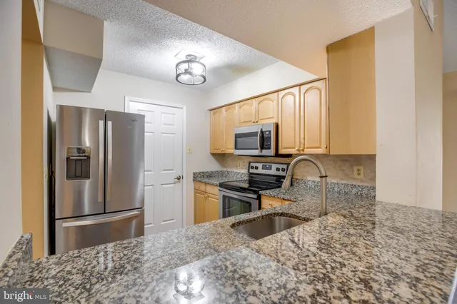 a kitchen with a refrigerator a stove a microwave and cabinets