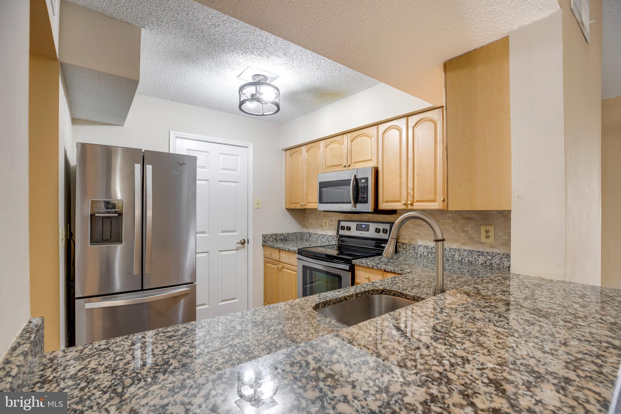 a kitchen with a refrigerator a stove a microwave and cabinets