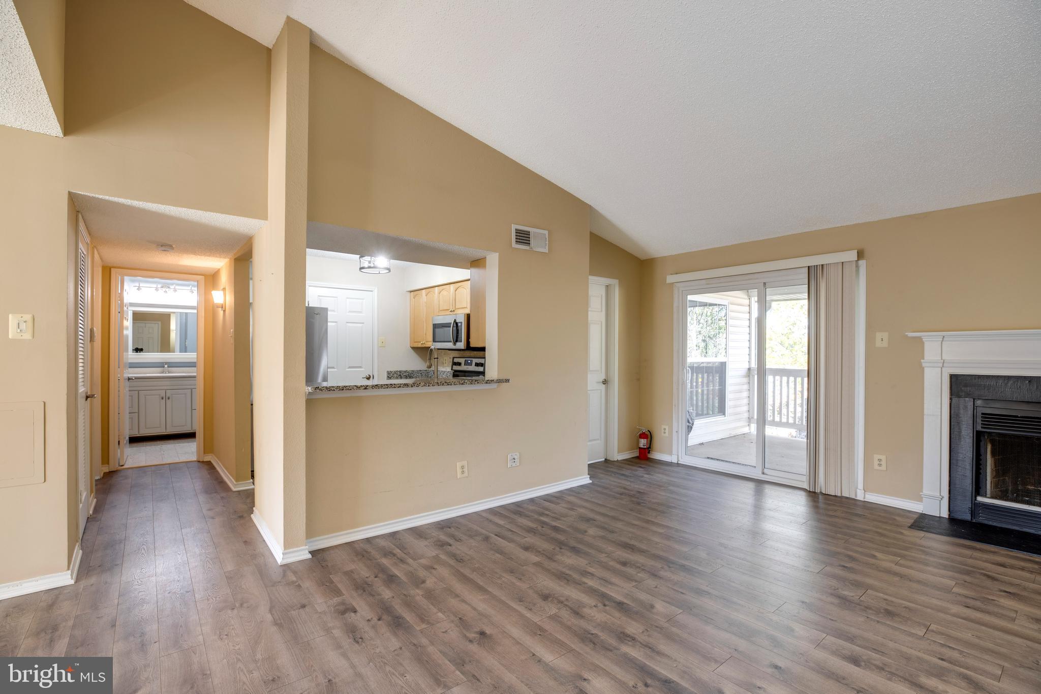 1543 Lincoln Way, Unit 301B McLean, VA 22102 - Photo 11 of 30 a view of a big room with wooden floor a fireplace and windows