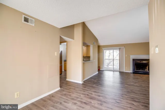 a view of a livingroom with wooden floor and a fireplace