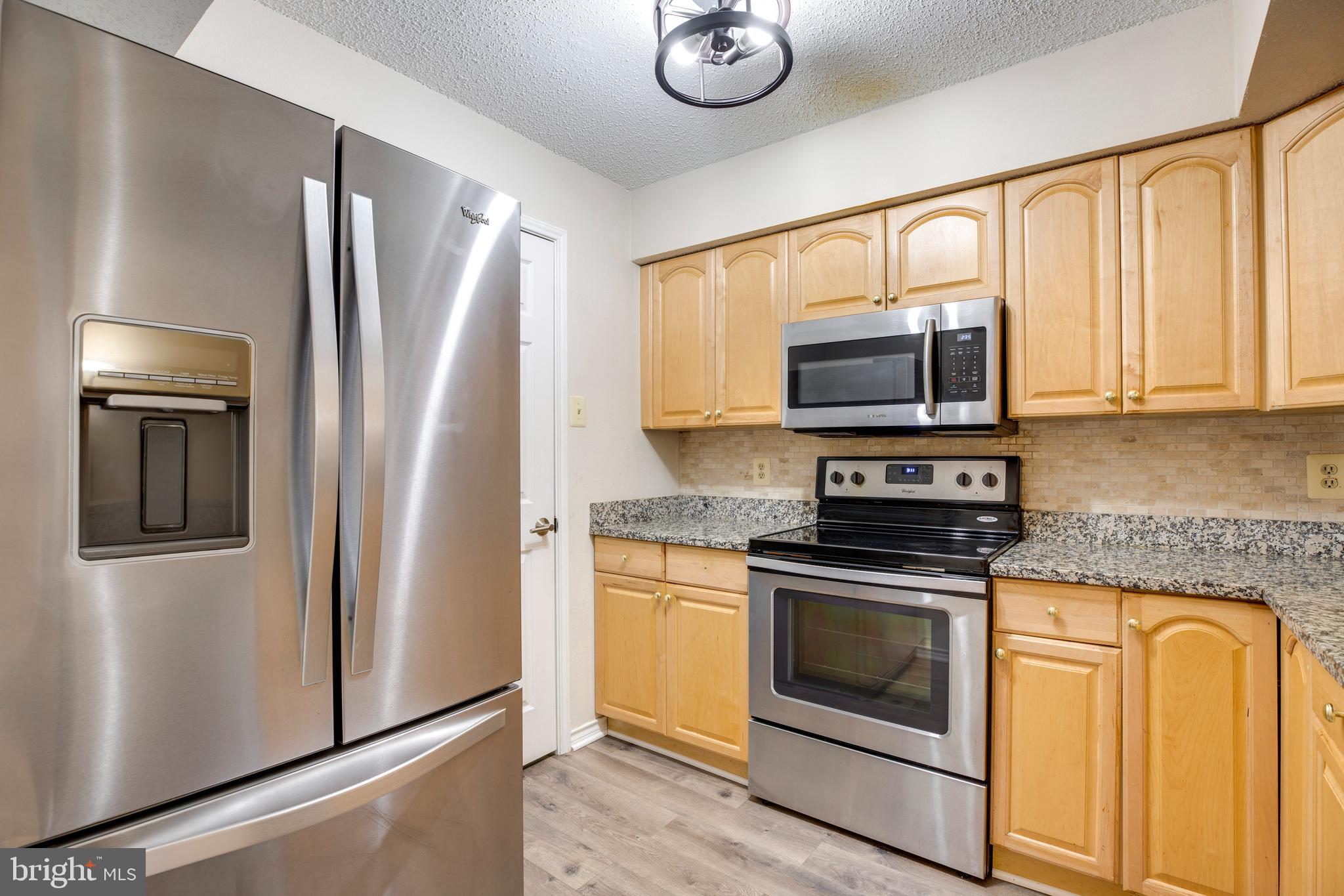 1543 Lincoln Way, Unit 301B McLean, VA 22102 - Photo 3 of 30 a kitchen with stainless steel appliances granite countertop a refrigerator stove and microwave
