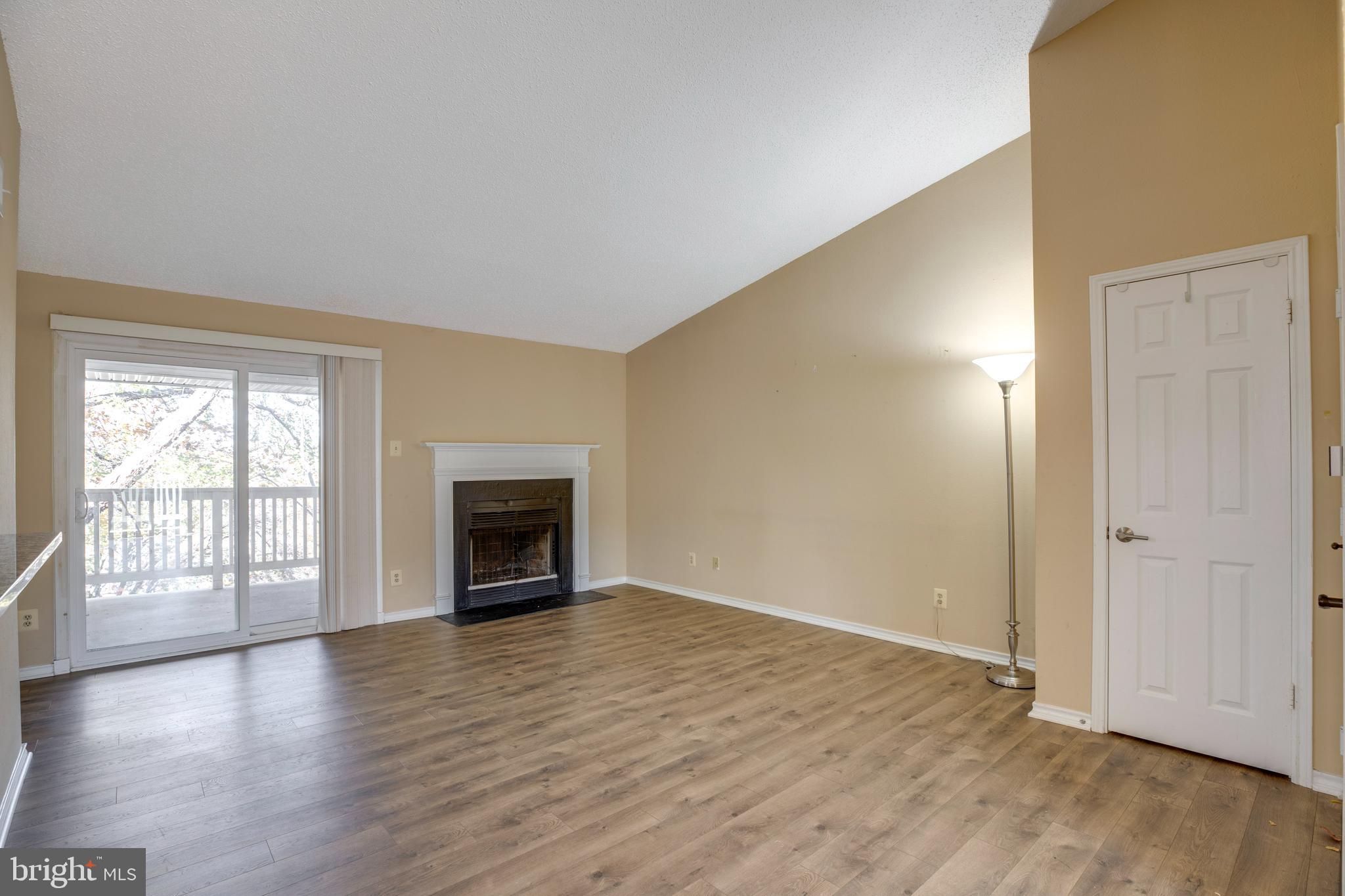 1543 Lincoln Way, Unit 301B McLean, VA 22102 - Photo 9 of 30 an empty room with wooden floor fireplace and windows