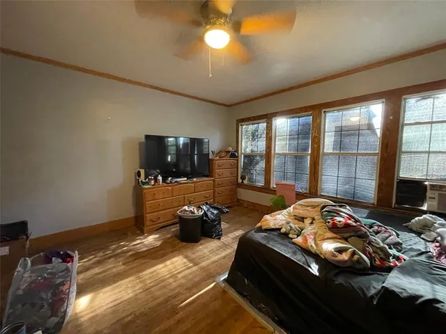 a bedroom with a bed and large windows