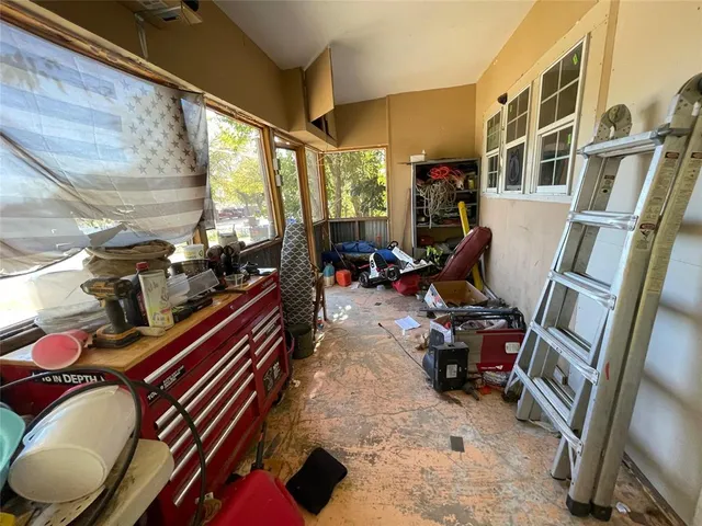 a living room with furniture gym equipment and a large window