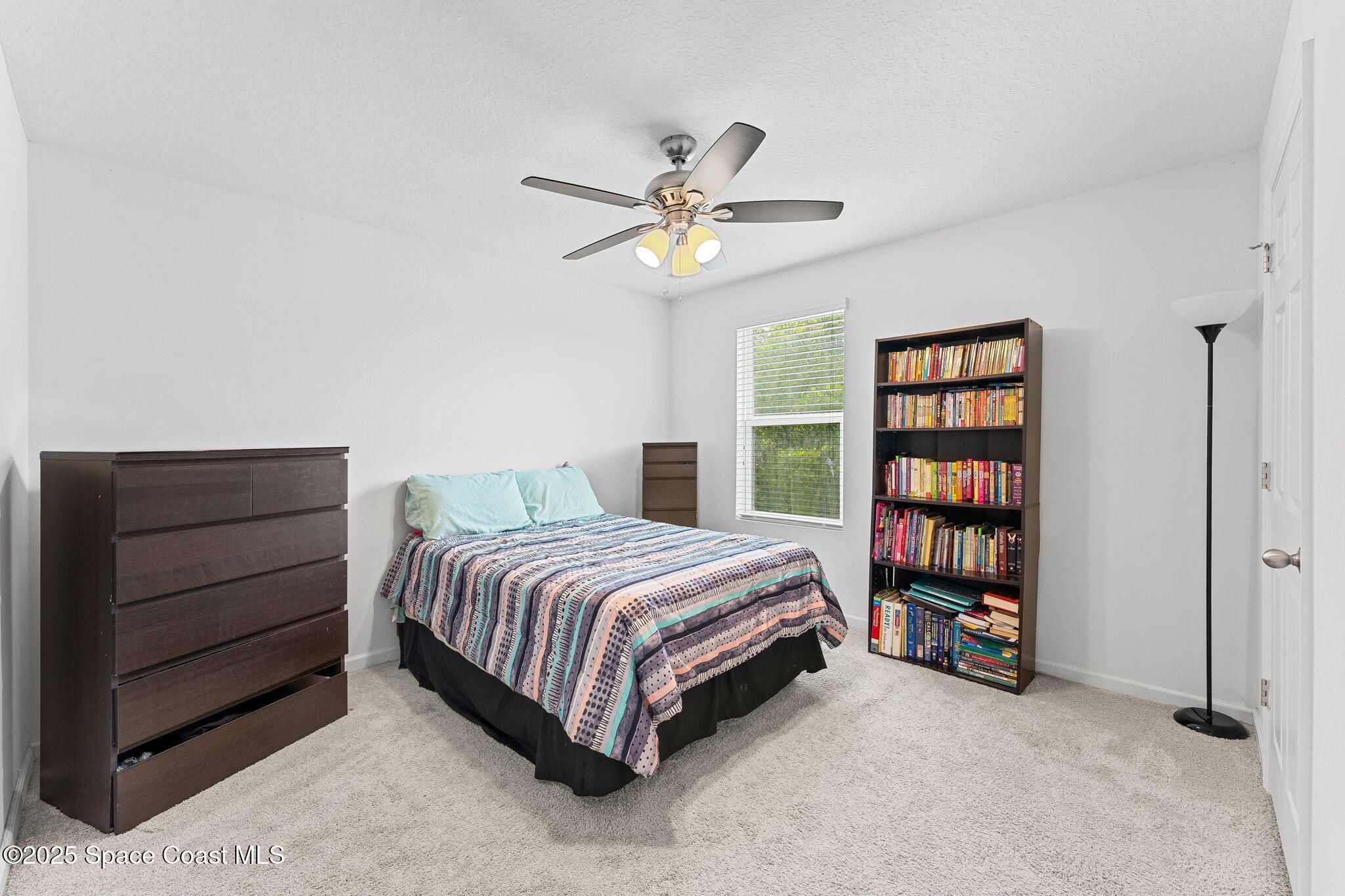 262 Alamere Drive Southwest Palm Bay, FL 32908 - Photo 18 of 34 a bedroom with a bed and a book shelf