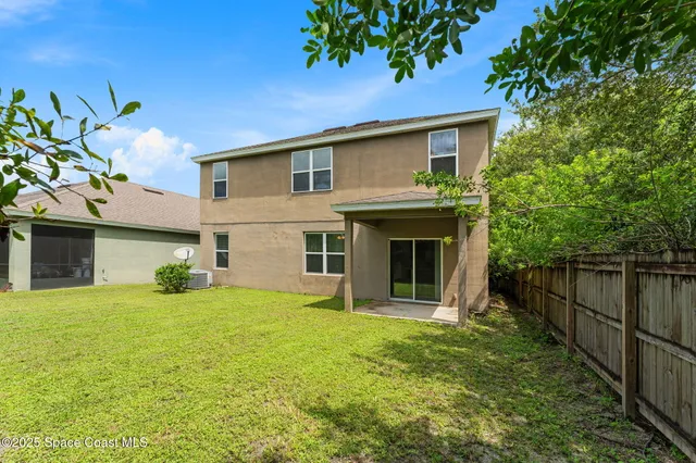 a view of a house with backyard and a tree
