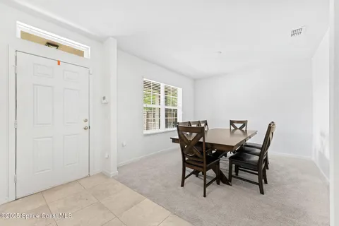 a living room with furniture kitchen view and a chandelier