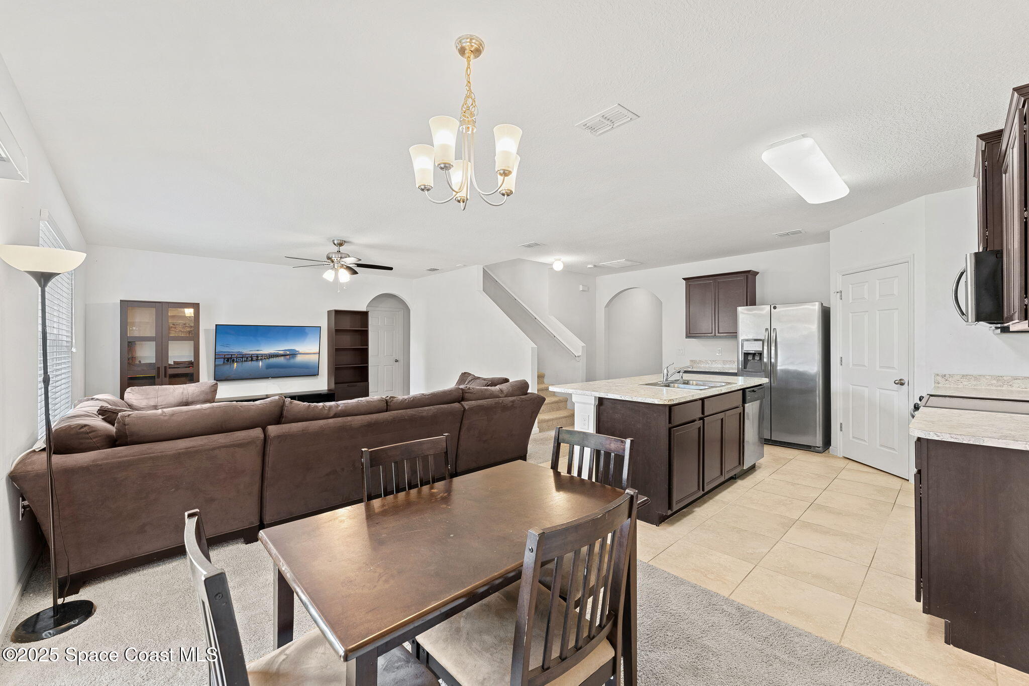 262 Alamere Drive Southwest Palm Bay, FL 32908 - Photo 5 of 34 a living room with furniture kitchen view and a chandelier