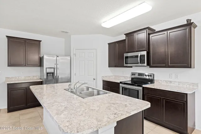 a kitchen with granite countertop a sink stove and refrigerator