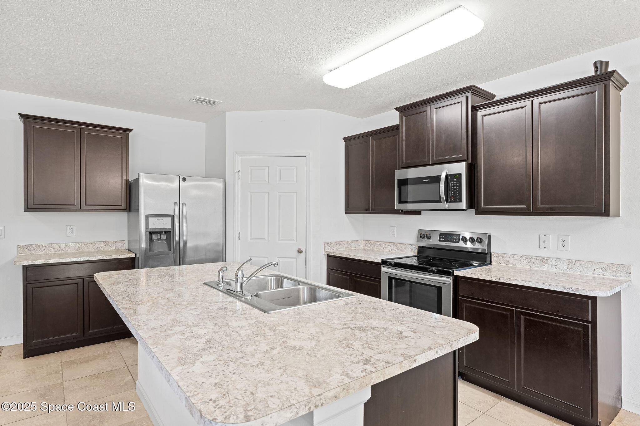 262 Alamere Drive Southwest Palm Bay, FL 32908 - Photo 8 of 34 a kitchen with granite countertop a sink stove and refrigerator