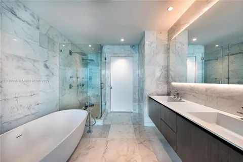 a bathroom with a double vanity sink a mirror and a bathtub