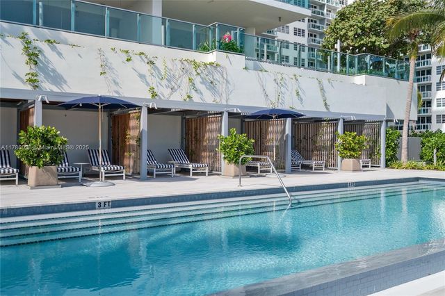 a hallway with a large window and view of kitchen