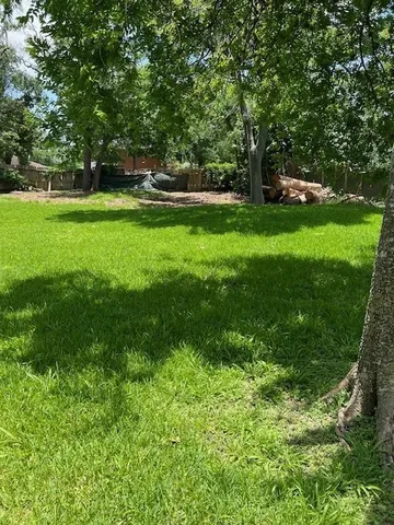 a view of green field with trees in the background