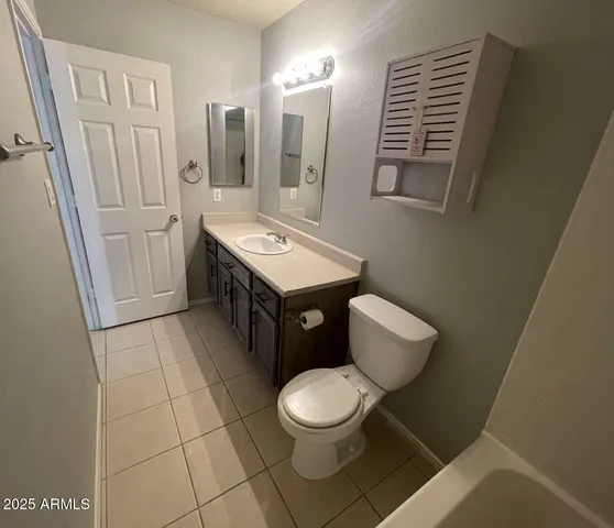 a bathroom with a toilet a sink and mirror