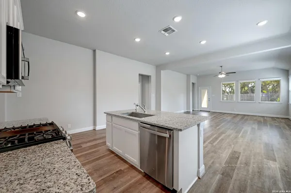 a kitchen with granite countertop a stove and a sink
