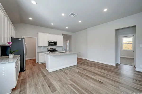 a kitchen with stainless steel appliances a refrigerator and a stove top oven