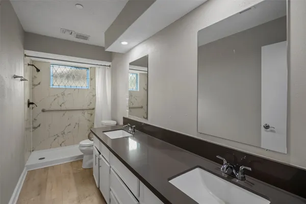 a bathroom with a sink a toilet and shower