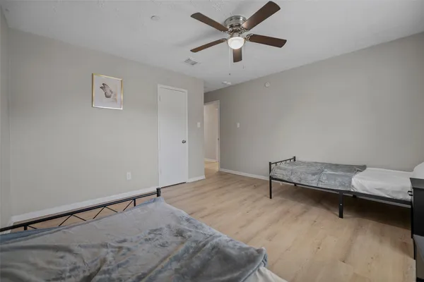 a hallway with a bed and a ceiling fan