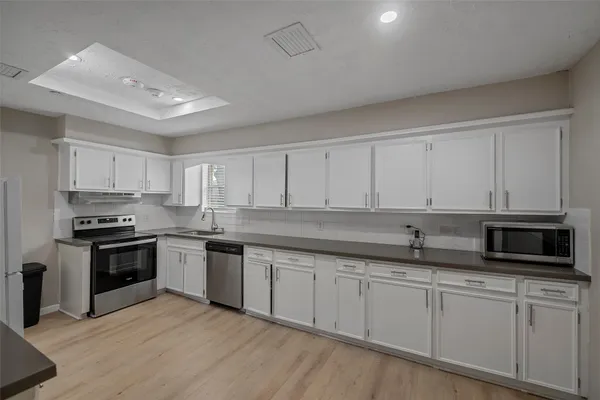a kitchen with stainless steel appliances granite countertop a stove a sink and a microwave