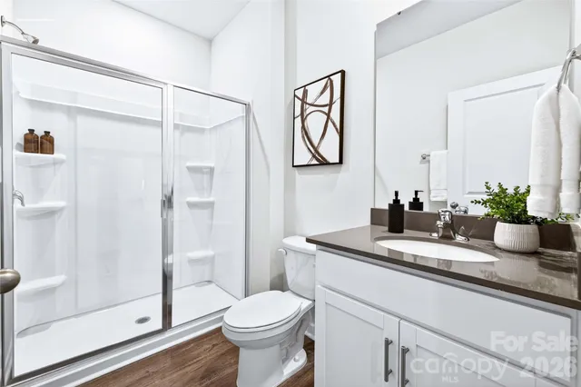 a bathroom with a granite countertop sink a toilet and shower