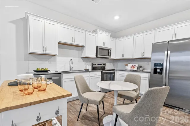 a kitchen with a dining table chairs and refrigerator