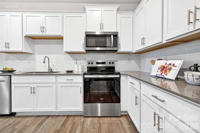 a kitchen with stainless steel appliances granite countertop a sink and a stove